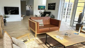 Una sala de estar moderna con un sofá, una mesa de centro de madera y un televisor.