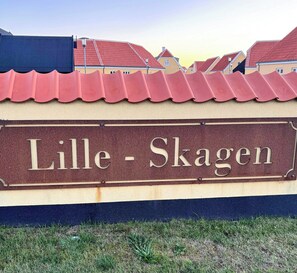 Una señal con el texto 'Lille - Skagen' que indica una ubicación.