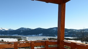 A wooden balcony with a view of snow-covered mountains and a lake. - Spacious 8-guests Holiday Apartment (Les Angles)