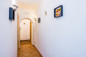 A hallway with a door, a wall-mounted light fixture, and a framed picture. - Maison Gennaro - Naples Heritage Stay (Naples)