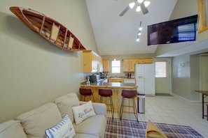 A compact living space with a kitchenette, a dining area with bar stools, a television mounted on the wall, and a sofa with decorative pillows. - Lake & Dock Access! Waterfront Hot Springs Haven (Hot Springs)