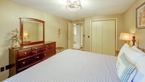 A hotel room with a bed, dresser, mirror, and a door leading to another room. - Lake & Dock Access! Waterfront Hot Springs Haven (Hot Springs)