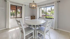 A dining area with a round table, six chairs, and a hanging light fixture. - Walk to Water! Boynton Beach Gem w/ Backyard Oasis (Boynton Beach)