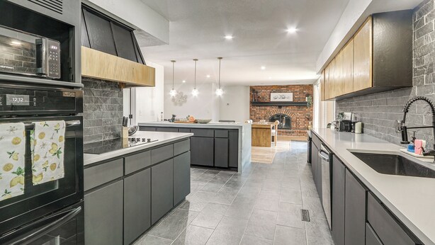 A modern kitchen with a central island, built-in appliances, and pendant lighting. - Great for Youth Sports Trips! Roomy Goddard Home (Goddard)
