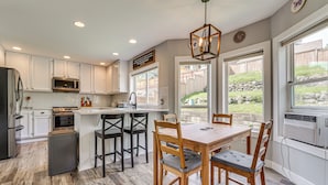 A kitchen with white cabinets, a wooden dining table, and a built-in oven. - Panoramic Views! Hilltop Haven in Seattle (Seattle)