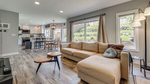 A modern living room with a sofa, a coffee table, and a dining area with chairs. - Panoramic Views! Hilltop Haven in Seattle (Seattle)