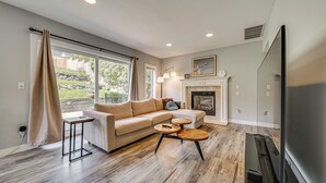 A living room with a sofa, two coffee tables, a fireplace, and a TV. - Panoramic Views! Hilltop Haven in Seattle (Seattle)