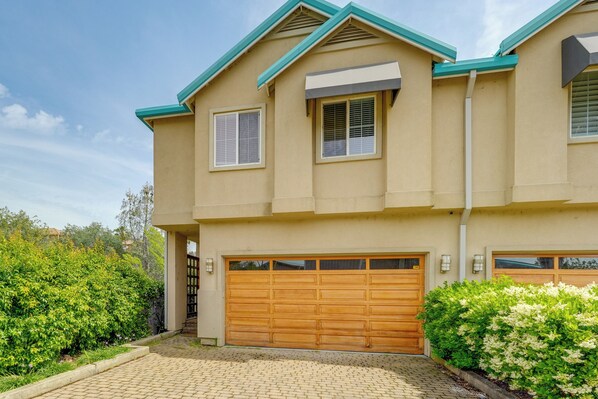 A two-story building with a garage, a covered walkway, and a landscaped garden. - Dodge Ridge & Bear Valley Day Trips! Lakefront Gem (Copperopolis)