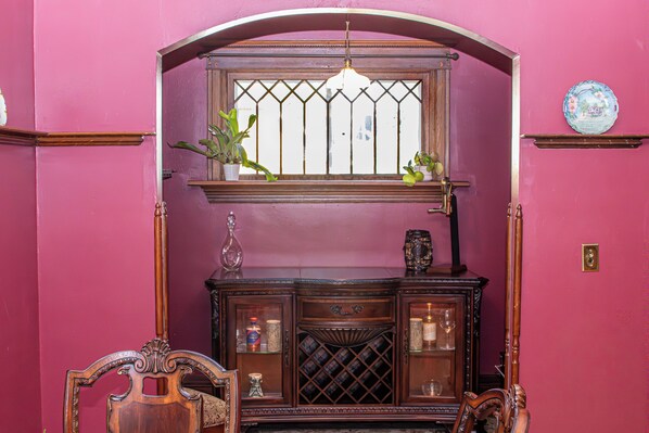 A room with a wooden cabinet, a window with bars, and a hanging light fixture.