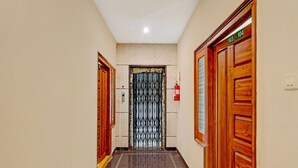 A hallway with wooden doors, a metal gate, and a fire extinguisher.