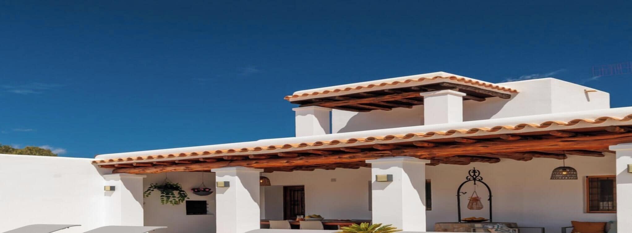 A modern building with a flat roof, white walls, and a wooden pergola.