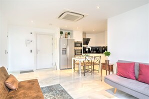 Un appartement moderne comprenant un coin repas, une cuisine et un salon.
