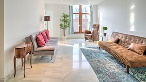 A modern living room with a sofa, armchair, and a small table. - 9-persons apartment in centre of Antwerp (belgium)