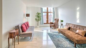 A modern living room with a sofa, armchair, and a small table.
