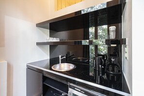 Een koffiezetapparaat/waterkoker, een koelkast, een magnetron, een oven