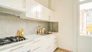 Una cocina moderna con armarios blancos, una estufa a gas y un lavabo.