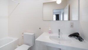 A bathroom with a white sink, mirror, and toilet. - Antwerp bright apartment stay (Antwerp)