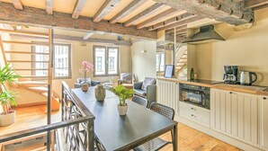 Una cocina acogedora con techo de madera, un comedor con mesa y sillas, y vistas al exterior.