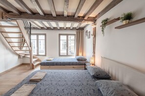 A room with a wooden staircase, two beds with patterned bedding, a window with curtains, and a shelf with plants. - Spacious 11-person stay in Antwerp (Antwerp)