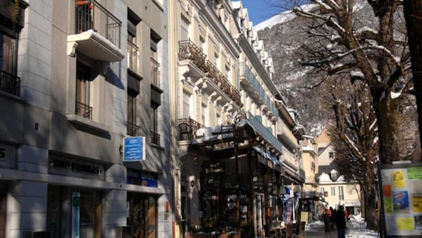 A street with buildings, a sign for 'Hotel de Ville,' and a mountain in the background. - Duplex Apartment in the Heart of Luchon (Bagneres-de-Luchon)