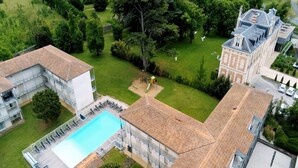 An aerial view of a residential area with a swimming pool, adjacent buildings, and a well-maintained lawn. - Spacious Stay for 6 in La Rochelle (Lagord)