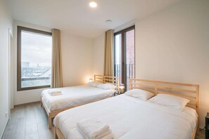 A hotel room with two beds, a large window, and a view of the city. - Executive 3BR Apartment in Antwerp (Antwerp)