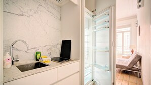 A bathroom with a marble wall, a sink with a faucet, and a towel rack. - 2-bedroom apartment in Antwerp Centre (Antwerp)