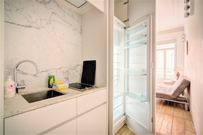 A bathroom with a marble wall, a sink with a faucet, and a towel rack. - 2-bedroom apartment in Antwerp Centre (Antwerp)
