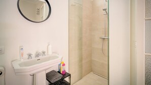 A bathroom with a sink, mirror, and shower. - 2-bedroom apartment in Antwerp Centre (Antwerp)