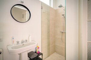 A bathroom with a sink, mirror, and shower. - 2-bedroom apartment in Antwerp Centre (Antwerp)