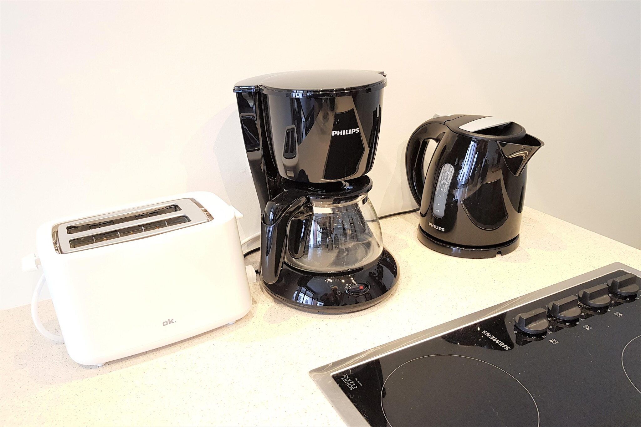 Eine Küche mit einer Philips-Kaffeemaschine, einem Toaster und einem Herd.