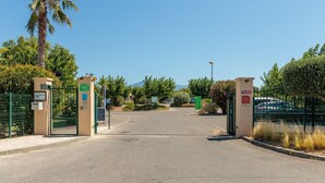 A gated entrance with a palm tree, a clear sky, and a mountain in the background. - Beautiful Holiday Home Near Vineyards (Aubignan)