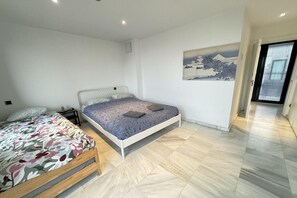 Ein Schlafzimmer mit einem Bett, einem Nachttisch, einem Wandregal und einem Gemälde.