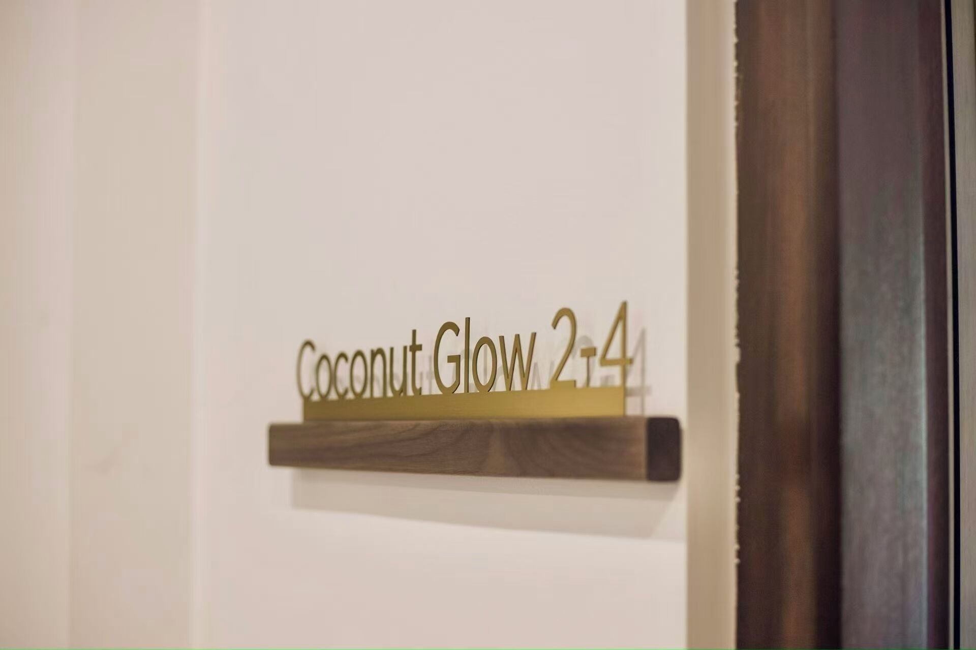 Una señal con el texto 'Coconut Glow 2-4' en una pared.