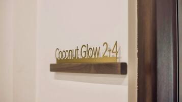 Een bord met de tekst 'Coconut Glow 2-4' aan een muur.