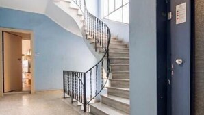 A hallway with a spiral staircase, a door, and a window. - STM Monastiraki Acropolis Apt (Athina)