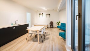 Una cucina moderna con zona pranzo, divano e una pianta.