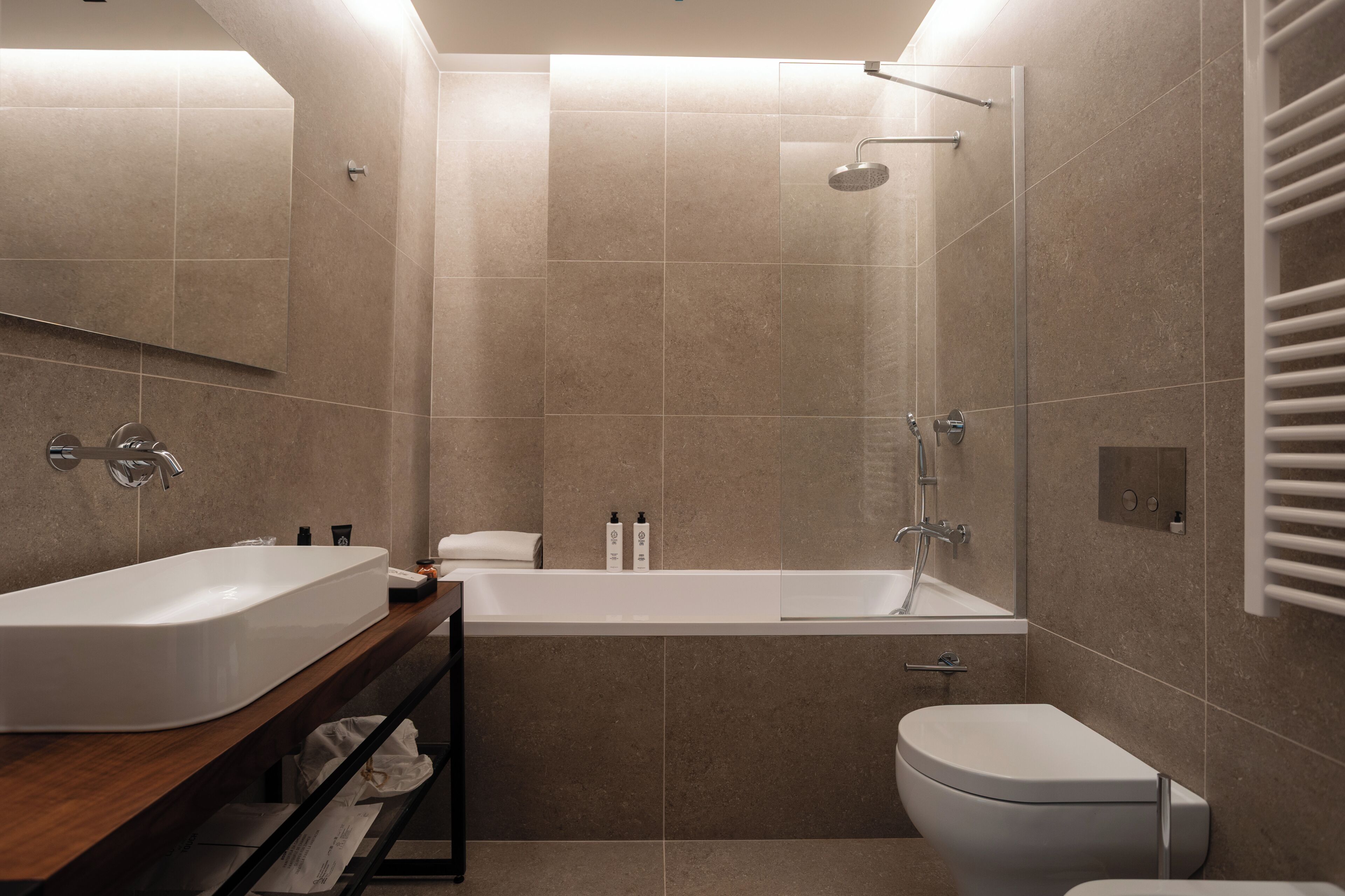 A modern bathroom with a large bathtub, a separate shower area, and a toilet.