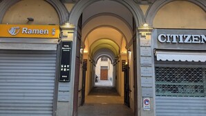 A building with a yellow facade, a Ramen restaurant on the left, and a Citizen hotel on the right. - Atelier Alinari Rooms (Florence)