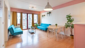 Un salon moderne avec un canapé, une table à manger, des chaises et une plante suspendue.