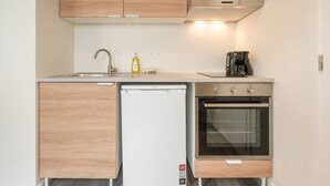 Una cocina compacta con armarios de madera, lavavajillas y horno.