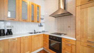 Een koffiezetapparaat/waterkoker, een koelkast, een oven, een kookplaat