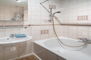 Ein Badezimmer mit Waschbecken, Spiegel und Badewanne.
