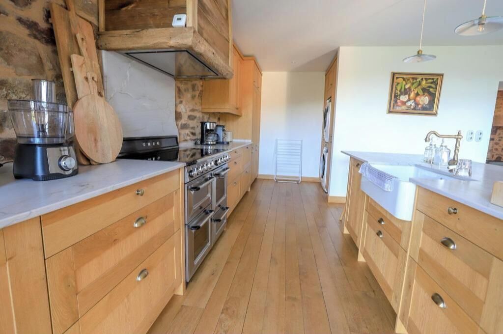 A kitchen with wooden cabinets, a built-in oven, and a coffee maker.