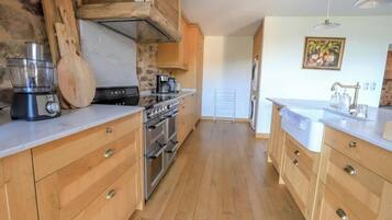 A kitchen with wooden cabinets, a built-in oven, and a coffee maker.