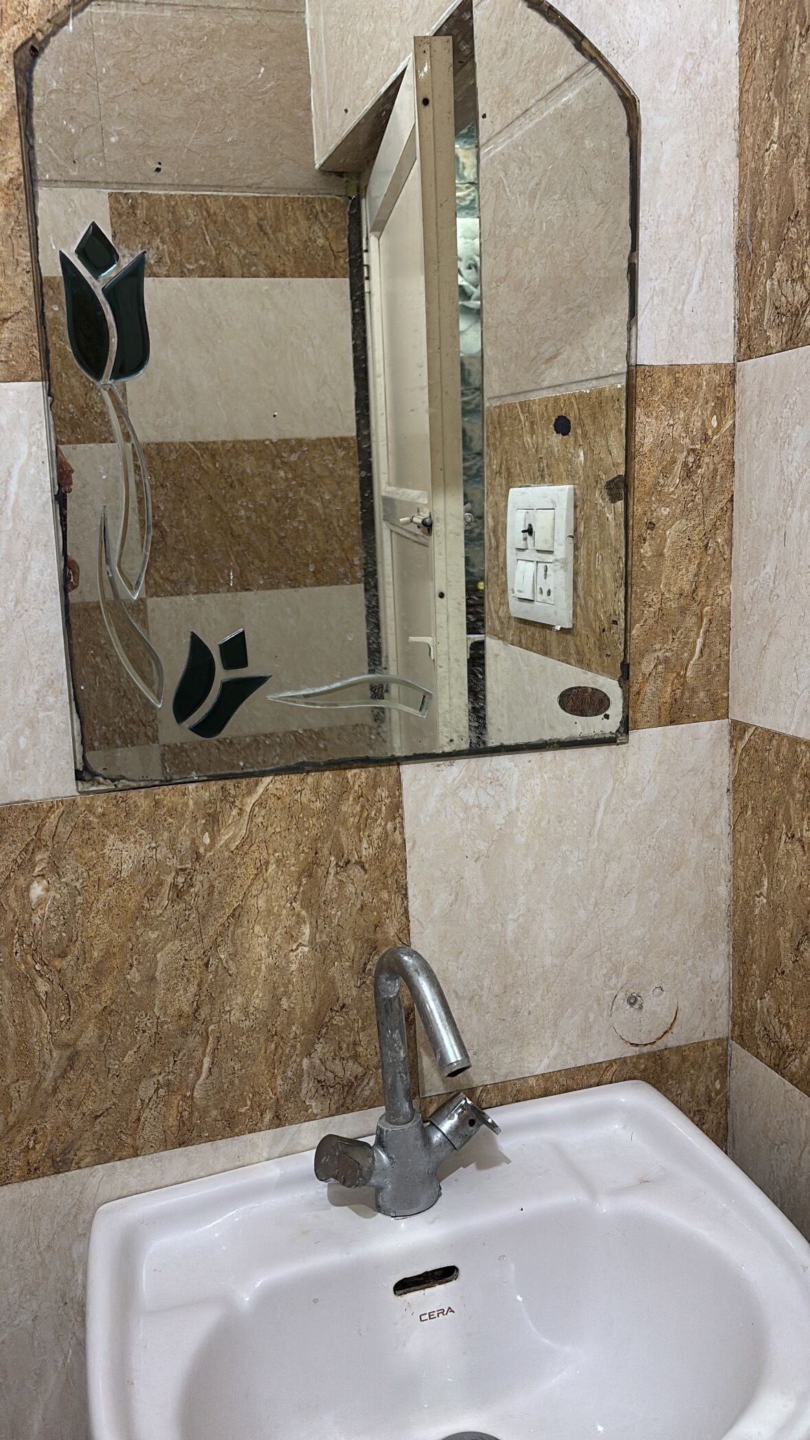 Un baño con lavabo, espejo y paredes de azulejos.