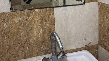 Un baño con lavabo, espejo y paredes de azulejos.