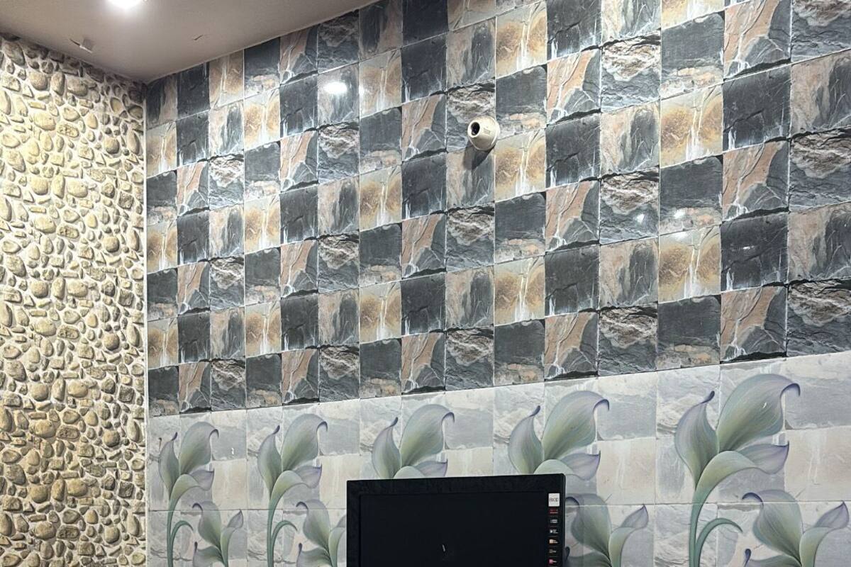 A room with a flat-screen TV mounted on a wall with a stone-like pattern.
