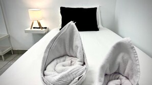 A bed with two white, round, cushioned footrests. - Hostal España (Arrecife)