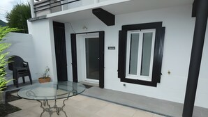 Uma casa moderna com mesa e cadeiras de vidro na área do pátio.